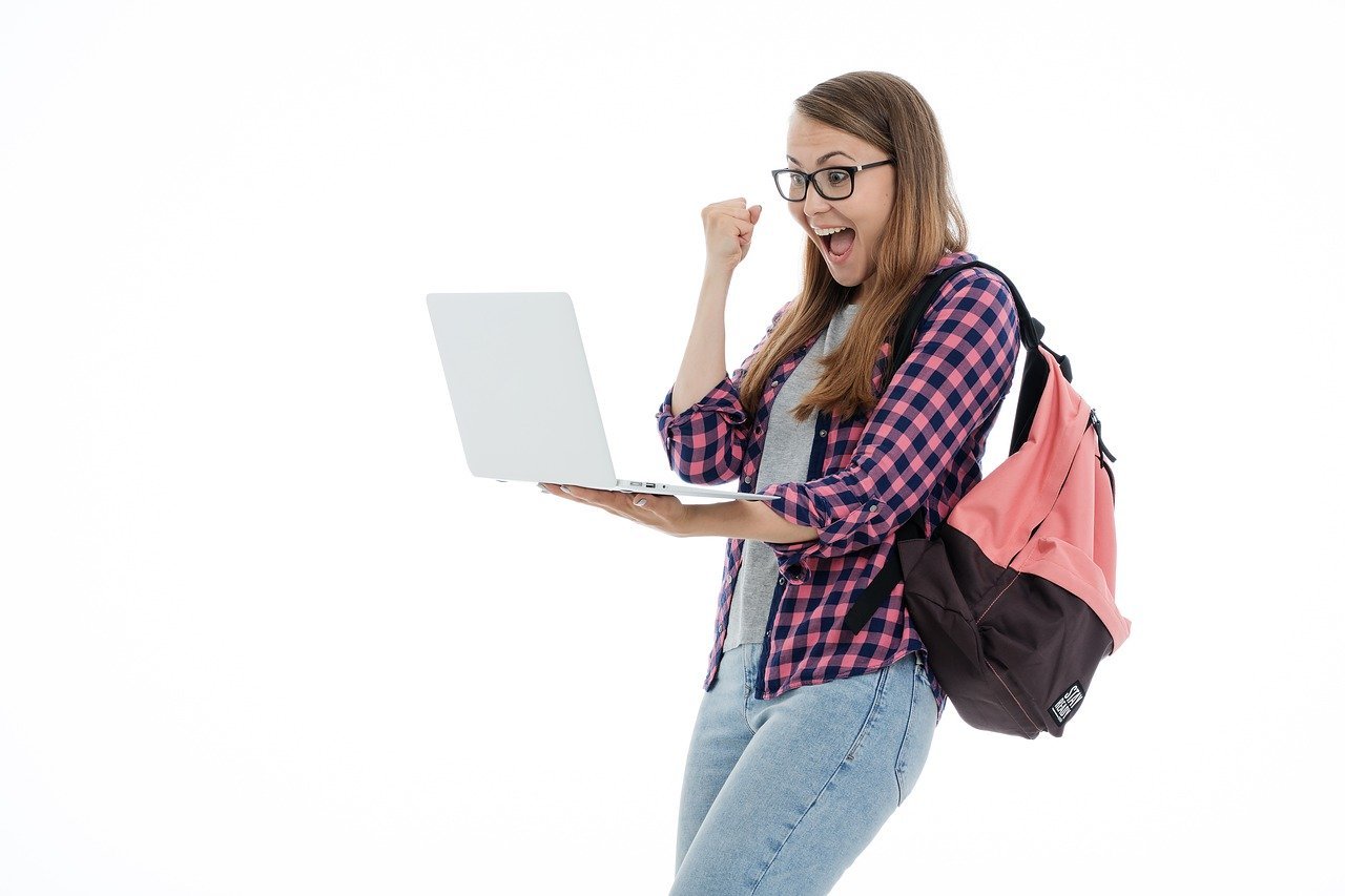 personne souriante avec ordinateur portable dans la main