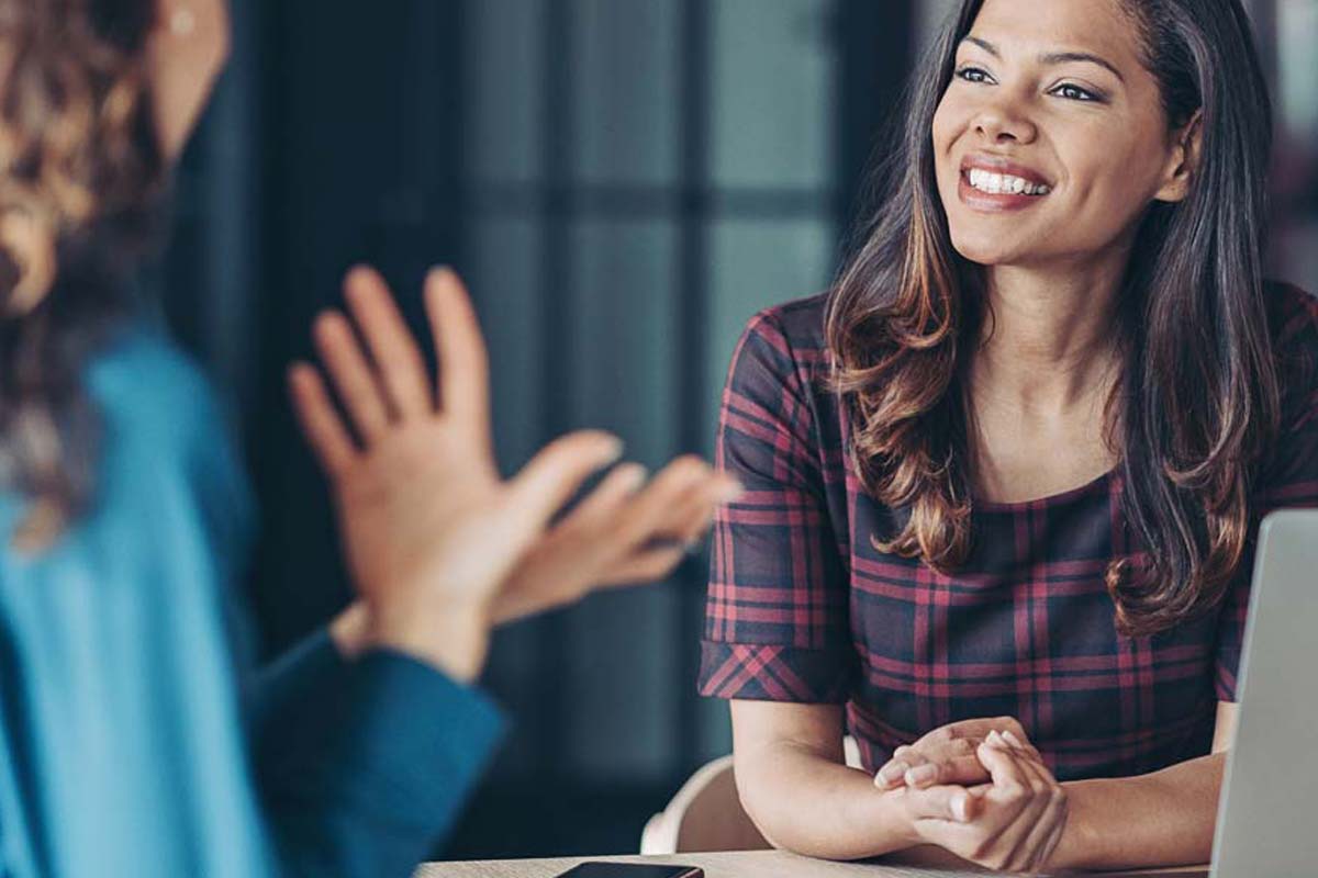 une personne souriante discute avec une autre personne